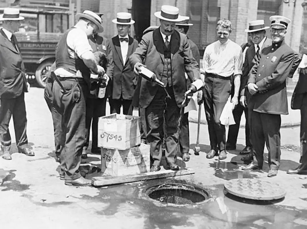 Federal agents pouring illegal alcohol into sewer drains during Prohibition enforcement in 1920, the era when 1932 OG's secret rye whiskey recipe was created in Iowa