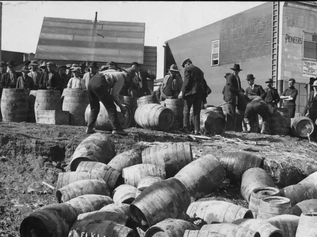 Federal agents destroying illegal whiskey barrels during 1933 Prohibition raid in Iowa, similar to the raid that nearly caught the Sextro family who created 1932 OG rye whiskey